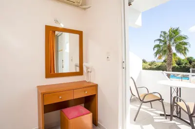 a bathroom with a mirror and a table and chairs at Sam's Faliraki in Faliraki