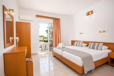 a bedroom with a large bed and a balcony at Sam's Faliraki in Faliraki