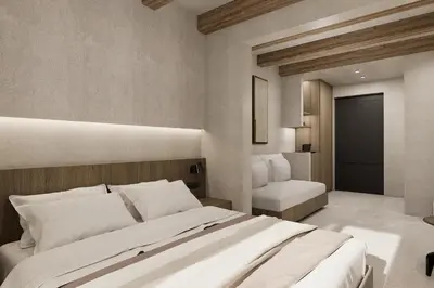 a bedroom with a large white bed and a chair at Sam's Faliraki in Faliraki