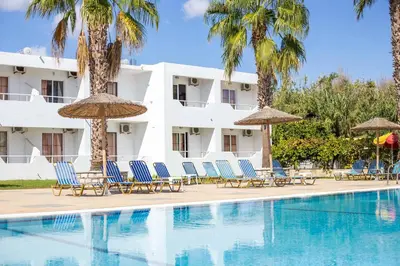 a hotel with chairs and umbrellas next to a swimming pool at Sam's Faliraki in Faliraki