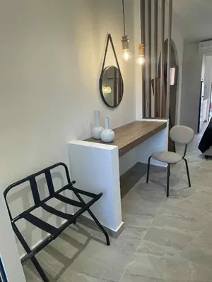 a room with a vanity with a mirror and two chairs at Kostas Studios in Faliraki