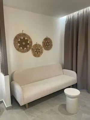 a living room with a couch and three hats on the wall at Kostas Studios in Faliraki