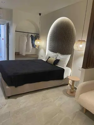 a bedroom with a large bed and two lamps at Kostas Studios in Faliraki
