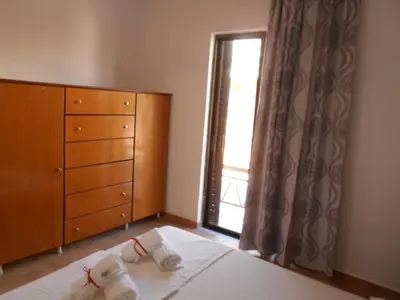 a bedroom with a bed with a dresser and a window at Village House in Kalithies