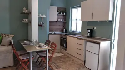 a kitchen with a table and a small kitchen with a table and chairs at Yalitzi in Symi