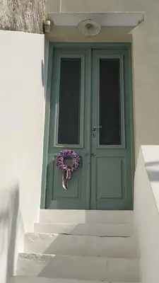 a green door with a purple wreath on it at Yalitzi in Symi