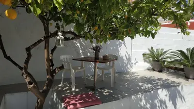 a table and two chairs next to a tree at Yalitzi in Symi
