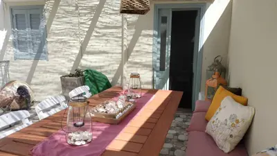 a wooden table with wine glasses on a patio at Yalitzi in Symi