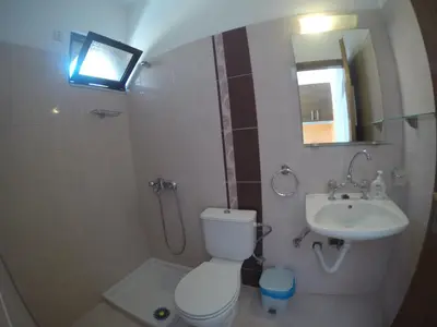 a small bathroom with a toilet and a sink at Yianna Studios in Faliraki