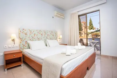 a bedroom with a large bed and a balcony at Yianna Studios in Faliraki