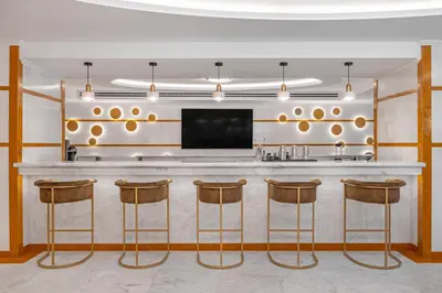 a bar in a room with stools and a television at Rhodos Horizon Boutique-Adults only in Rhodes Town