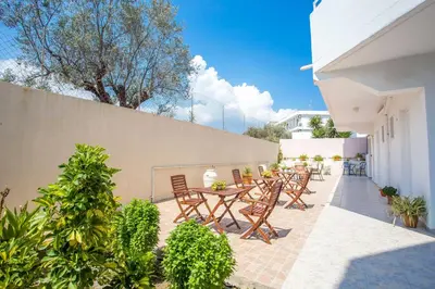 a patio with a table and chairs and a fence at Iatridis Studios Faliraki in Faliraki