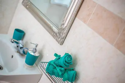 a bathroom with a mirror and a green towel at Iatridis Studios Faliraki in Faliraki