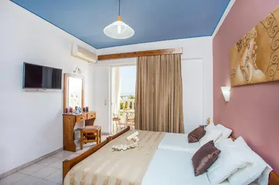 a hotel room with a bed and a window at Iatridis Studios Faliraki in Faliraki
