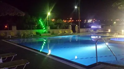 a swimming pool at night with ducks in it at Summer Days in Faliraki