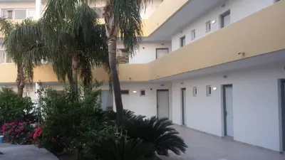 a building with two garage doors and palm trees at Summer Days in Faliraki