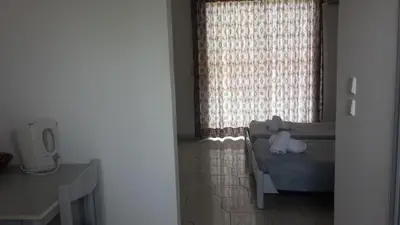 a teddy bear sitting on a couch in front of a window at Summer Days in Faliraki