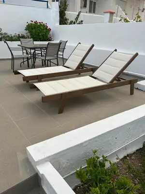 a row of wooden benches sitting on a patio at Corafili Holiday Suites in Kiotari
