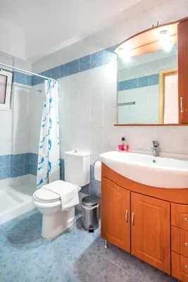 a bathroom with a toilet and a sink and a tub at Corafili Holiday Suites in Kiotari