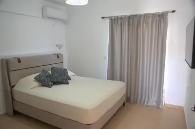 a bedroom with a bed with two pillows on it at Corafili Holiday Suites in Kiotari