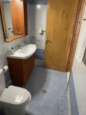 a bathroom with a toilet and a sink and a door at Corafili Holiday Suites in Kiotari