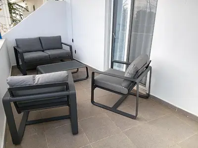 two chairs and a couch sitting on a balcony at Corafili Holiday Suites in Kiotari