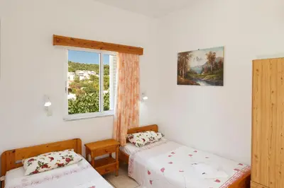 a bedroom with two beds and a window at Villa Stamatis in Pefki Rhodes
