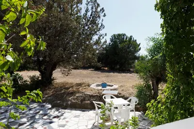 a patio with two white chairs and a table at Villa Stamatis in Pefki Rhodes