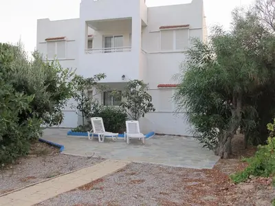 two white chairs sitting in front of a building at Villa Stamatis in Pefki Rhodes