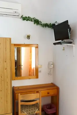 a bathroom with a mirror and a desk with a television at Villa Stamatis in Pefki Rhodes