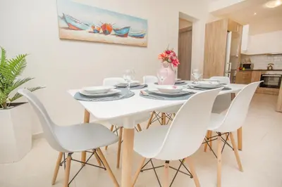a white dining room with a white table and chairs at Rhodes Marine House in Rhodes Town