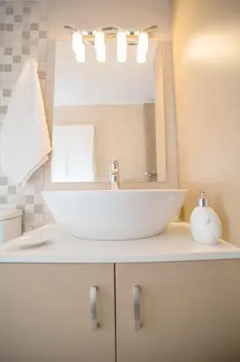 a bathroom with a white sink and a mirror at Rhodes Marine House in Rhodes Town