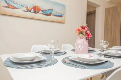 a white table with plates and a vase with flowers at Rhodes Marine House in Rhodes Town
