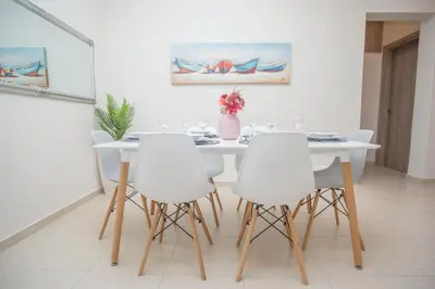 a white dining room with a white table and white chairs at Rhodes Marine House in Rhodes Town