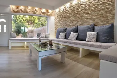 a living room with a couch and a table at Sea Breeze Villa in Haraki