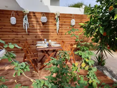 a wooden fence with a table and chairs in a garden at Sea Breeze Villa in Haraki