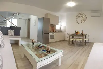 a large living room with a table and a kitchen at Sea Breeze Villa in Haraki