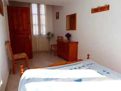 a bedroom with a bed and a dresser and a door at Villa Yorgos in Halki