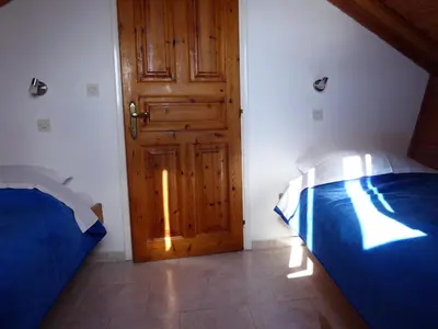 a bedroom with a blue bed and a wooden door at Villa Yorgos in Halki