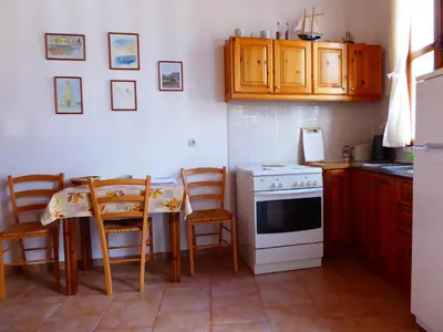 a kitchen with a table and a white stove top oven at Villa Yorgos in Halki