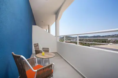 a balcony with chairs and a table and a window at Mazoren Art Hotel in Faliraki