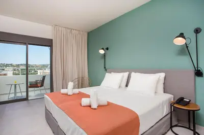 a bedroom with a large bed and a balcony at Mazoren Art Hotel in Faliraki
