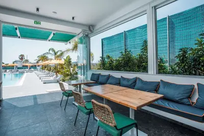 a patio with a blue couch and a table and chairs at Mazoren Art Hotel in Faliraki