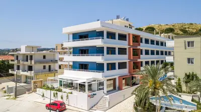 a large white building with a red van in front of it at Mazoren Art Hotel in Faliraki