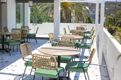 a row of tables and chairs on a patio at Mazoren Art Hotel in Faliraki