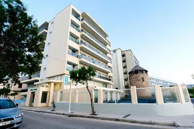 a building with a tower on the side of a street at Hotel Riviera in Rhodes Town