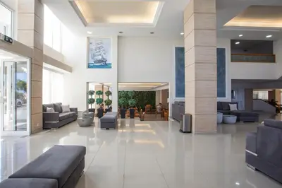 a lobby with couches and chairs in a building at Hotel Riviera in Rhodes Town