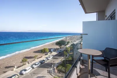 a balcony with a view of a beach and the ocean at Hotel Riviera in Rhodes Town