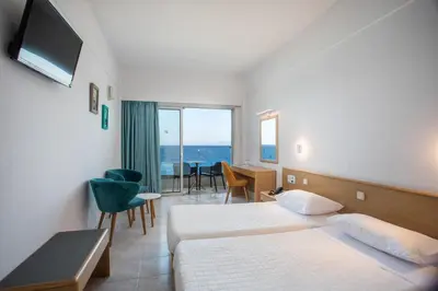 a hotel room with two beds and a television at Hotel Riviera in Rhodes Town