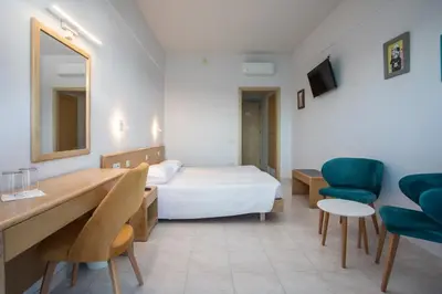 a hotel room with a bed and a desk and chairs at Hotel Riviera in Rhodes Town